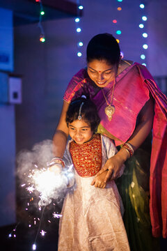 Mother and daughter having fun with sparkler
