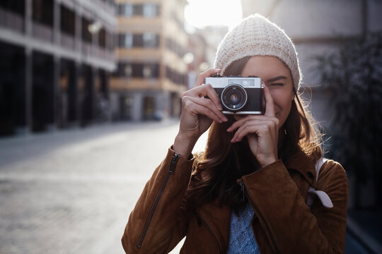 Young woman taking pictures in the city