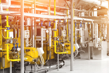 Interior of modern industrial gas boiler room with two gas boilers and pipes for supplying gas and steam. Sun flarers