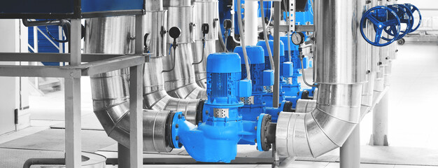 Modern industrial boiler room with pumps and pipe lines supplying steam with pressure gauges installed in. Blue toning. Panoramic banner. - obrazy, fototapety, plakaty