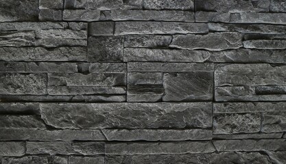 Black stone cladding wall made with different block panels stacked Background and texture.	