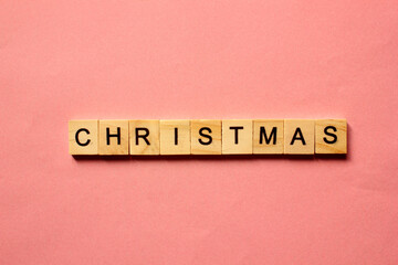 Word Christmas. Wooden blocks with inscription on pink background. The bulletin board. Concept of...
