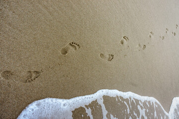 Two footprints on the sea sand. Walking on the beach.
