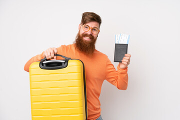 Redhead man with long beard over isolated white background in vacation with suitcase and passport