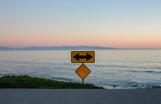 Sign with arrows pointing left and right at the end of the road