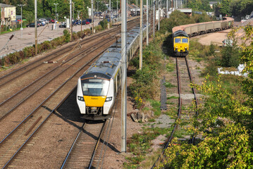 Southbound passenger train passes freight in Hitchin goods yard
