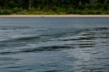 Simple landscape with the freshwater river don in the Rostov region. Warm season, summer, cloudy sky over the sandy beach and green vegetation.
