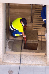 sewer utility workers with hose and pressurized water working inside a building  by a flood