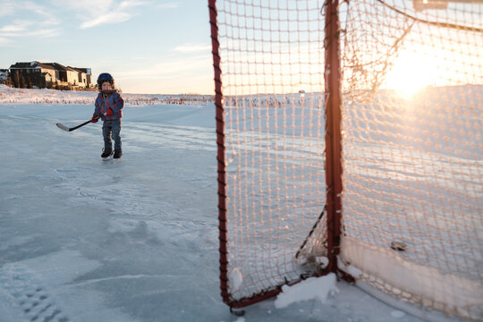 A toddler just after shooting a puck into the net