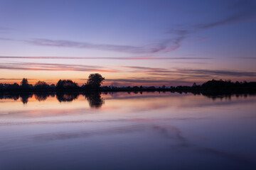 Fototapeta na wymiar Clouds after sunset over a calm lake