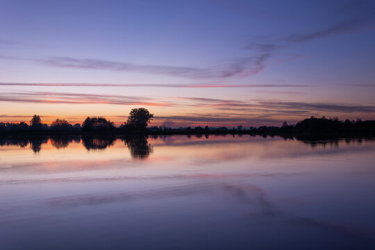 Clouds after sunset over a calm lake © darekb22