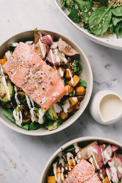 Salmon over roasted veggie spinach and grain salad