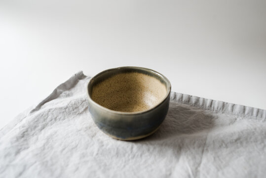 Handmade two toned neutral and light blue modern ceramic pottery cup on white table