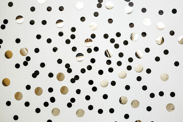 Lots of silver confetti on a white festive background.