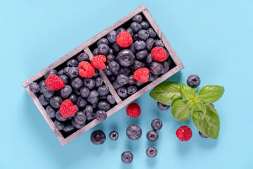 blueberries and raspberries in wooden crates.