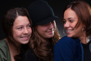 three beautiful friends smiling, studio light, neutral background