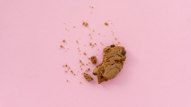 Creative concept flatlay stop motion media video movie footage chocolate cookie bite on pink background.