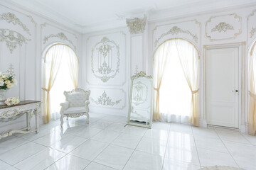 luxury royal posh interior in baroque style. very bright, light and white hall with expensive oldstyle furniture. large windows and stucco ornament decorations on the walls