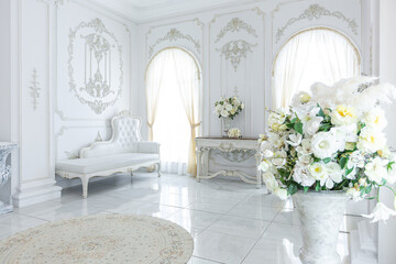 luxury royal posh interior in baroque style. very bright, light and white hall with expensive oldstyle furniture. large windows and stucco ornament decorations on the walls