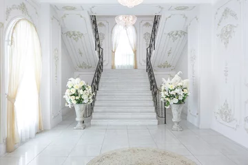 Fotobehang Hotel chique luxury royal posh interior in baroque style. very bright, light and white hall with expensive oldstyle furniture. chic wide marble staircase leading to the second floor  © 4595886