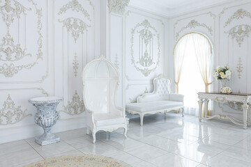 luxury royal posh interior in baroque style. very bright, light and white hall with expensive oldstyle furniture. large windows and stucco ornament decorations on the walls