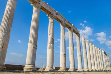 View in perspective onto antique street colonnade. All columns made in Corinthian order. Picture taken in ancient city Laodicea, near Denizli, Turkey