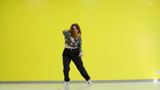 Girl dancing hip hop on the background of a yellow wall. Isolated.