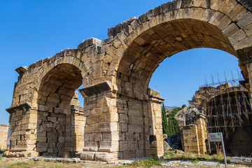 Close view onto facade of ancient basilica in antique city Hierapolis, Pamukkale, Turkey. Building was used as urban public bath. It was damaged by earthquake, now restoring. Included in UNESCO List