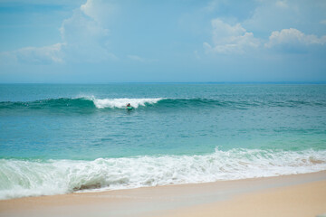 The guy is swimming on the surf board on the ocean. Healthy active lifestyle in summer vocation.