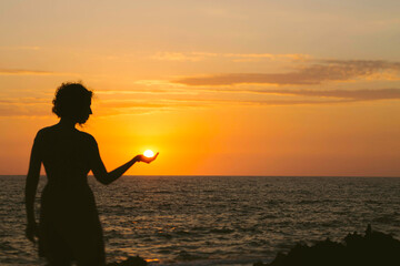 Woman playing with the sun