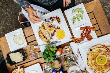 Aerial shot of a table full of breakfast food such as pancakes, eggs, bacon and juice