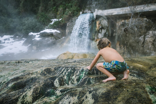 toddler having fun in natural hot springs outdoors in winter