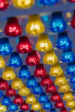 Red, yellow and blue fairground lights under a canopy at night
