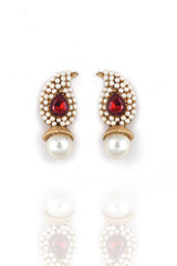 Beautiful pair of earrings pearl with red gemstone on a white background. Luxury female jewelry, Indian traditional jewellery, ,Bridal Gold earrings wedding jewellery