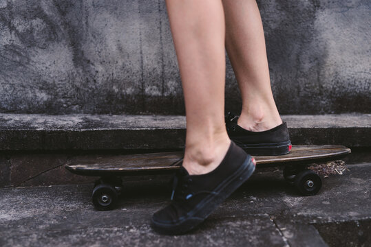 Close up of teen girl riding a skateboard