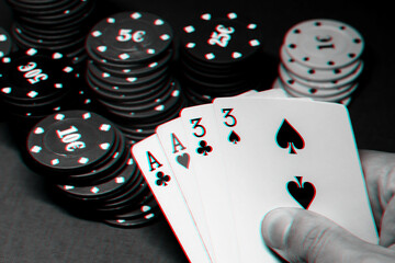 cards with two pairs in poker in the hands of a gambler on the background of gaming chips