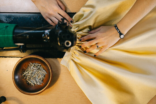 Woman sewing gold skirt