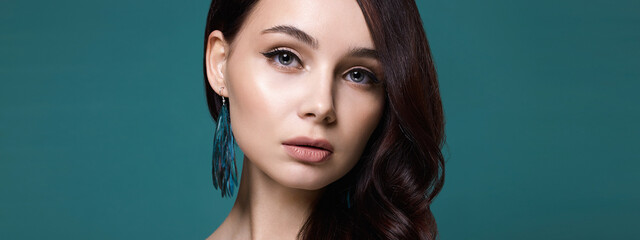 Beautiful young woman with bird feathers earring