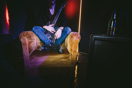 Guitarist Sitting on Velvet Armchair