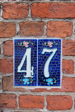 A beautiful old house number on a brick wall.
