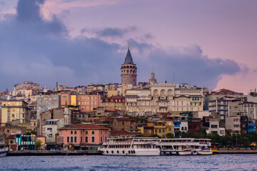 Fototapeta premium Panoramic view onto Karaköy quarter & its famous Galata Tower, Istanbul, Turkey. Also there old minaret of old mosque, neighbourship of ancient & modern buildings, tourist boats & local ferries.