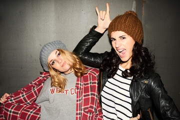 Blonde and brunette girls in hats making faces and gesturing at