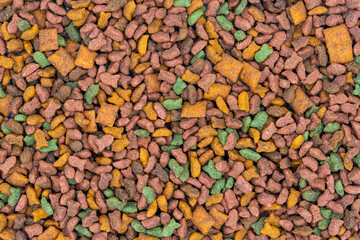 Dry cat food flat lay. Grainy kibble photo texture. Fish and chicken food for cats and dogs. Dry nutrition for domestic animals. Pet food texture for package design. Dry grainy meal fish flavoured