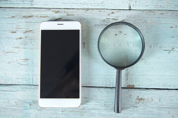 phone and magnifying glass on table