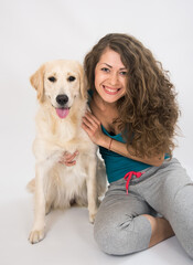 Portrait of curly smile young woman and golden retriever dog closeup isolated on white background. Beautiful woman stroking her dog.