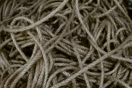 Tangled inextricable skein of long linen rope. Limited depth of field.