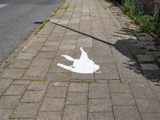 Spilled white paint on a sidewalk in the city center.