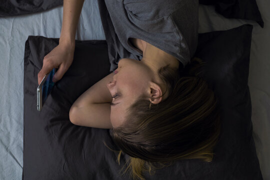 Woman browsing phone in bed