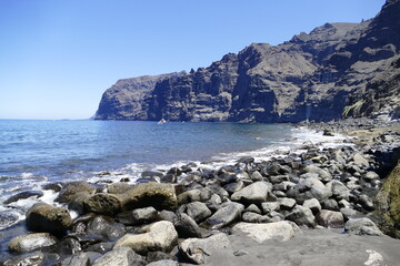 Rocky beach across Los Gigantes rocks  in Atlantic Ocean on Tenerife, Spain. 