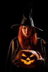 Wicked witch holding a jack-o-lantern for halloween